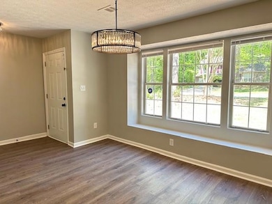 Unfurnished dining area with dark wood-type floori