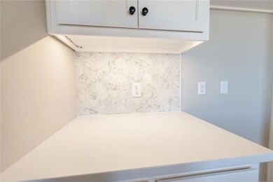 Kitchen with exhaust hood, white cabinets, light c