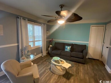 Living room with ceiling fan and wood-type floorin