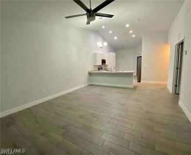 Unfurnished living room featuring ceiling fan, vau