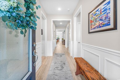 Hallway featuring a wainscoted wall, a decorative 