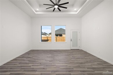 Unfurnished room featuring wood tiled floors, a ceiling fan, a raised ceiling, and recessed lighting