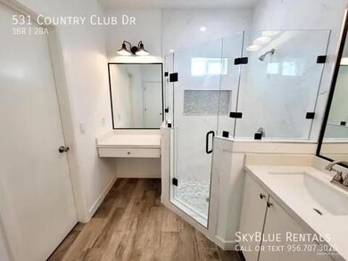 Bathroom featuring vanity, an enclosed shower, and hardwood / wood-style floors