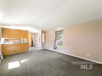 Unfurnished living room featuring lofted ceiling and carpet flooring