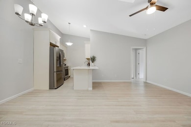 Kitchen with open floor plan, light countertops, c