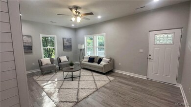 Living room featuring ceiling fan and hardwood / w