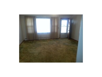 Spacious carpeted living room with hardwood undern