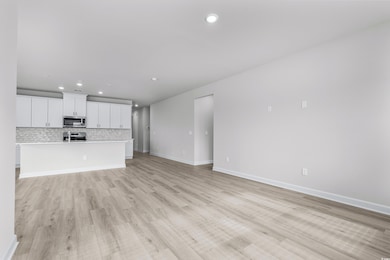 Unfurnished living room featuring light hardwood /