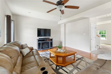 Living room featuring a ceiling fan, light wood-st
