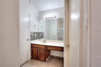 Bathroom with vanity, tasteful backsplash, and tile patterned flooring