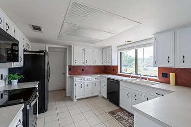 Kitchen with visible vents, light countertops, a 