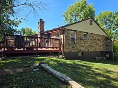 Back of property featuring a lawn and a deck