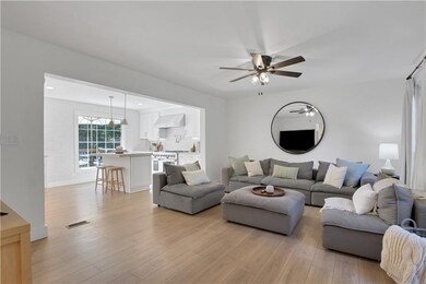 Living area featuring light wood-style floors and a ceiling fan