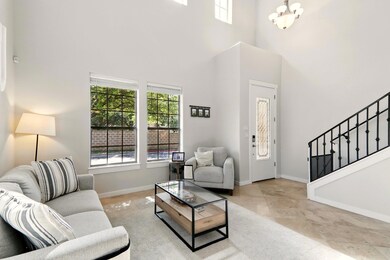 Living area featuring a towering ceiling, stairwa