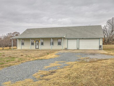 Ranch-style home featuring covered porch and a garage