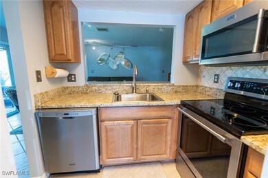 Kitchen featuring light stone counters, stainless