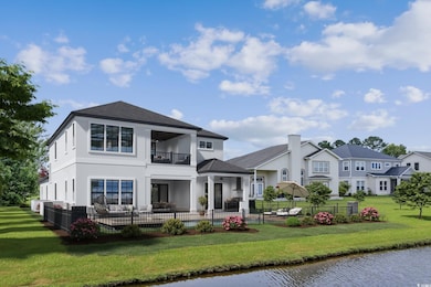 Back of property with a ceiling fan, fence, a yard, and a balcony