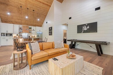 Living room featuring high vaulted ceiling, light wood-type flooring, wood walls, wooden ceiling, and recessed lighting