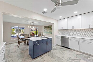Island sink with a view.  Honed Calcutta marble counters throughout. Open to dining and living areas.