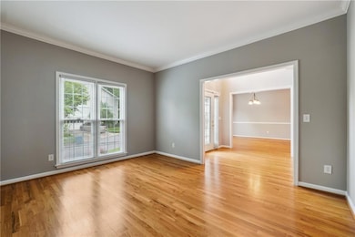 Spare room featuring light hardwood / wood-style floors and crown molding