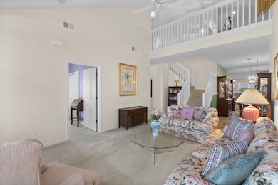 Living room featuring stairs, baseboards, a high c