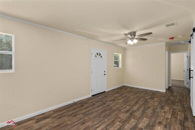 Spare room featuring a barn door, dark wood-type f