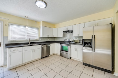 Enjoy cooking in this welcoming kitchen with sleek stainless steel appliances and durable tile floors that make cleanup effortless. There’s ample space for a breakfast table, perfect for casual mornings or family meals.