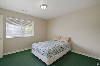 Bedroom featuring carpet flooring and baseboards