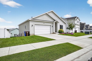 View of front of home with concrete driveway, a front yard, and an attached garage