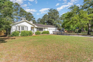 View of front of home featuring a front yard, driv