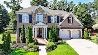 Colonial-style house with concrete driveway, a shingled roof, brick siding, and a front yard