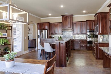 Enormous kitchen with double ovens, gas cooktop, and stainless appliances.