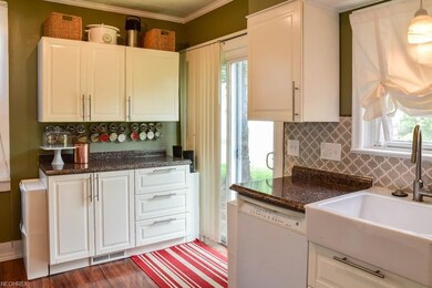 The kitchen has beautiful white cabinets with soft