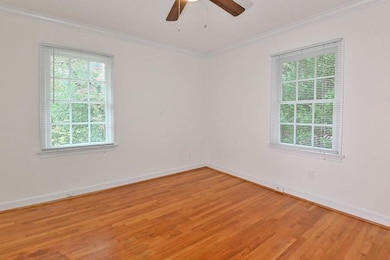 Empty room with light wood-style flooring and crown molding