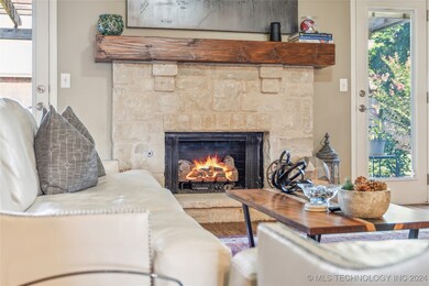 Stone fireplace with gas starter and wood mantel