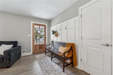 Sitting room featuring a textured ceiling and light wood-style flooring