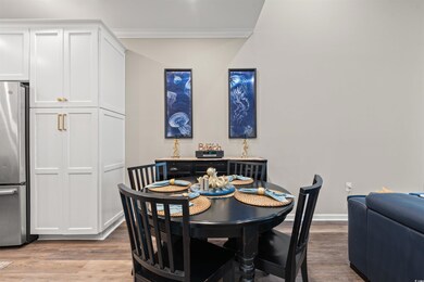 Dining room featuring baseboards, crown molding, and light wood-style flooring
