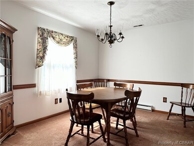 Carpeted dining area featuring baseboard heating a