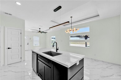 Kitchen featuring visible vents, dishwasher, a sink, dark cabinets, and marble finish floor