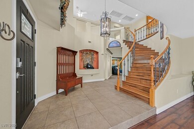 Tiled entrance foyer featuring stairs, baseboards,