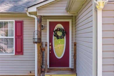 Doorway to property featuring a shingled roof