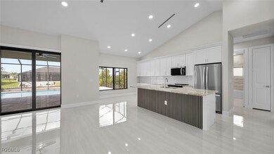 Kitchen with appliances with stainless steel finishes, a center island with sink, recessed lighting, white cabinetry, and tasteful backsplash