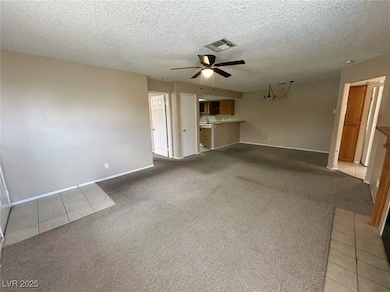 Unfurnished living room featuring ceiling fan, car