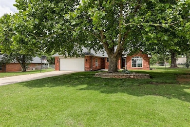 Obstructed view of property with concrete driveway, brick siding, and an attached garage