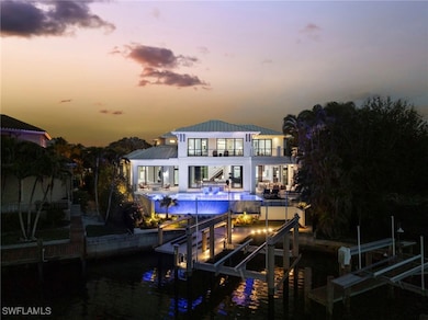 Back house at dusk featuring a patio, a balcony, a