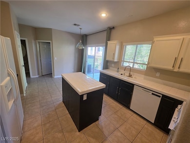 Kitchen featuring tile counters, light tile patterned flooring, white appliances, a kitchen island, and recessed lighting