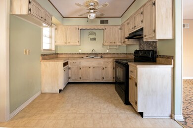 Kitchen featuring ceiling fan, black electric rang