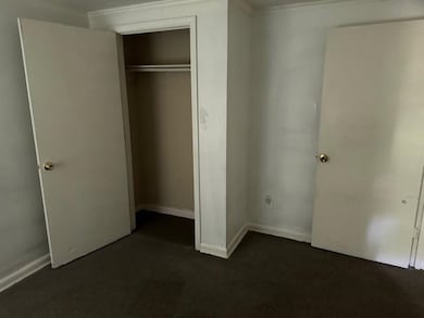 Unfurnished bedroom featuring dark colored carpet,