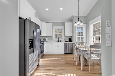 Kitchen featuring white cabinets, a wealth of natu