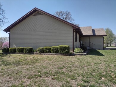 Features landscaping rock and hedges.